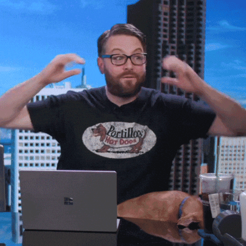 Man at a laptop making a "mind blown" gesture with both hands