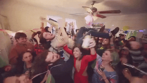 A packed room of people jumping and celebrating at a party